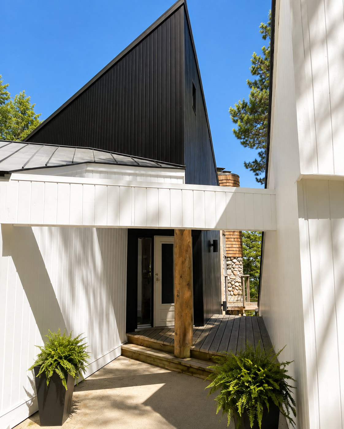 Entry courtyard with white siding, black gable, and a cedar post