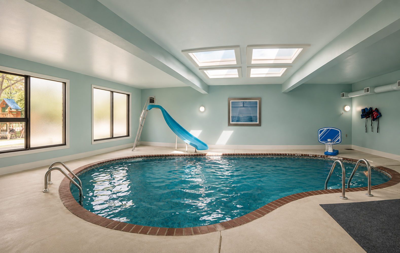 Indoor pool room with soft aqua walls and white ceiling beams