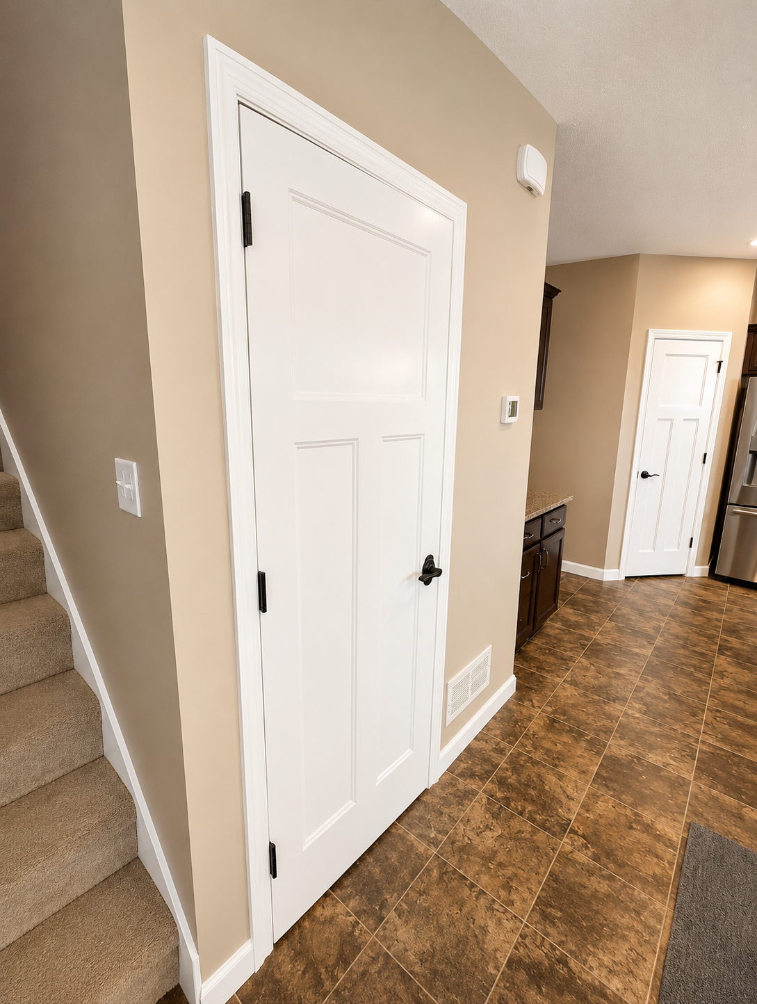 Hallway with warm beige walls and freshly painted white doors and trim