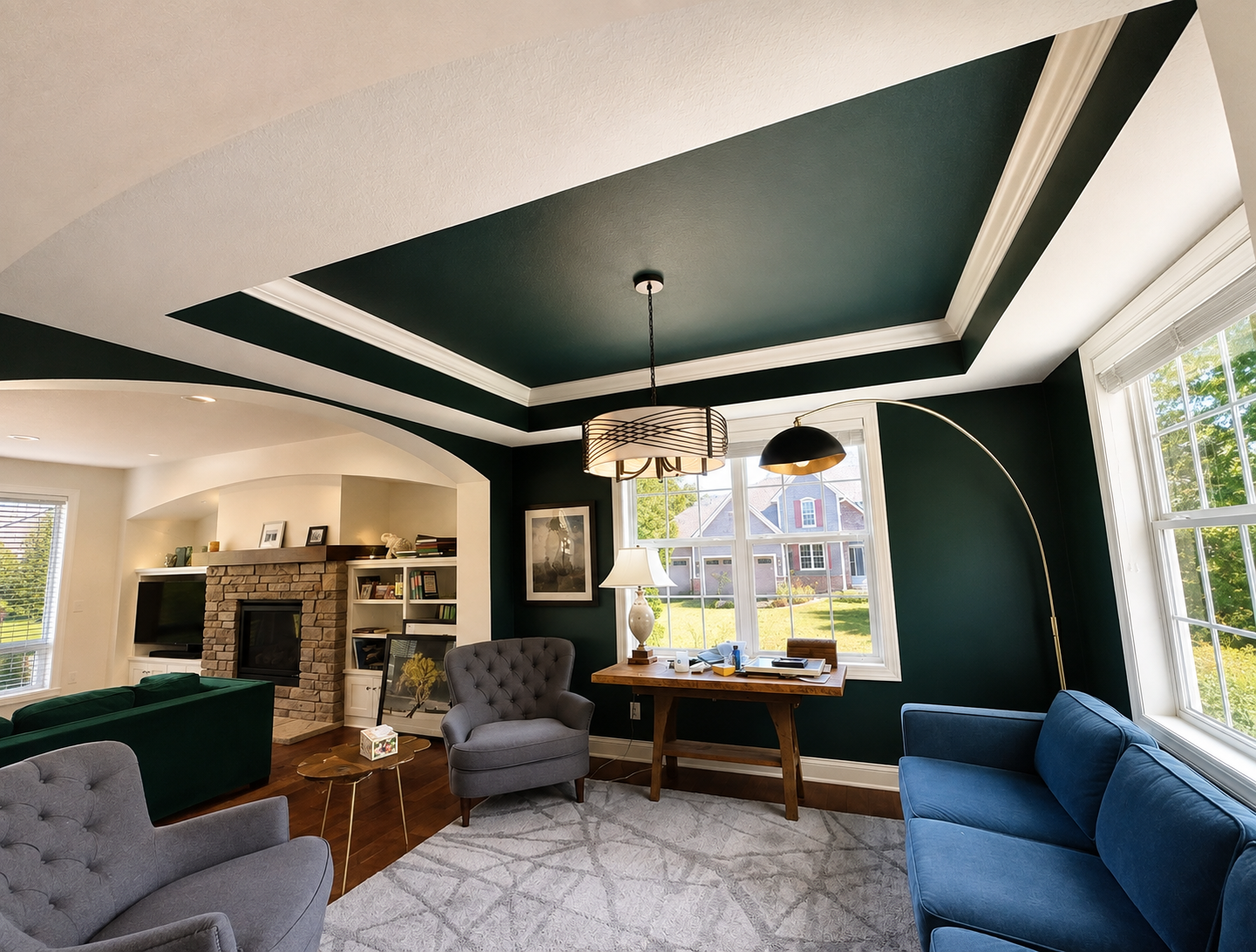 Living room with deep green walls and a green tray ceiling